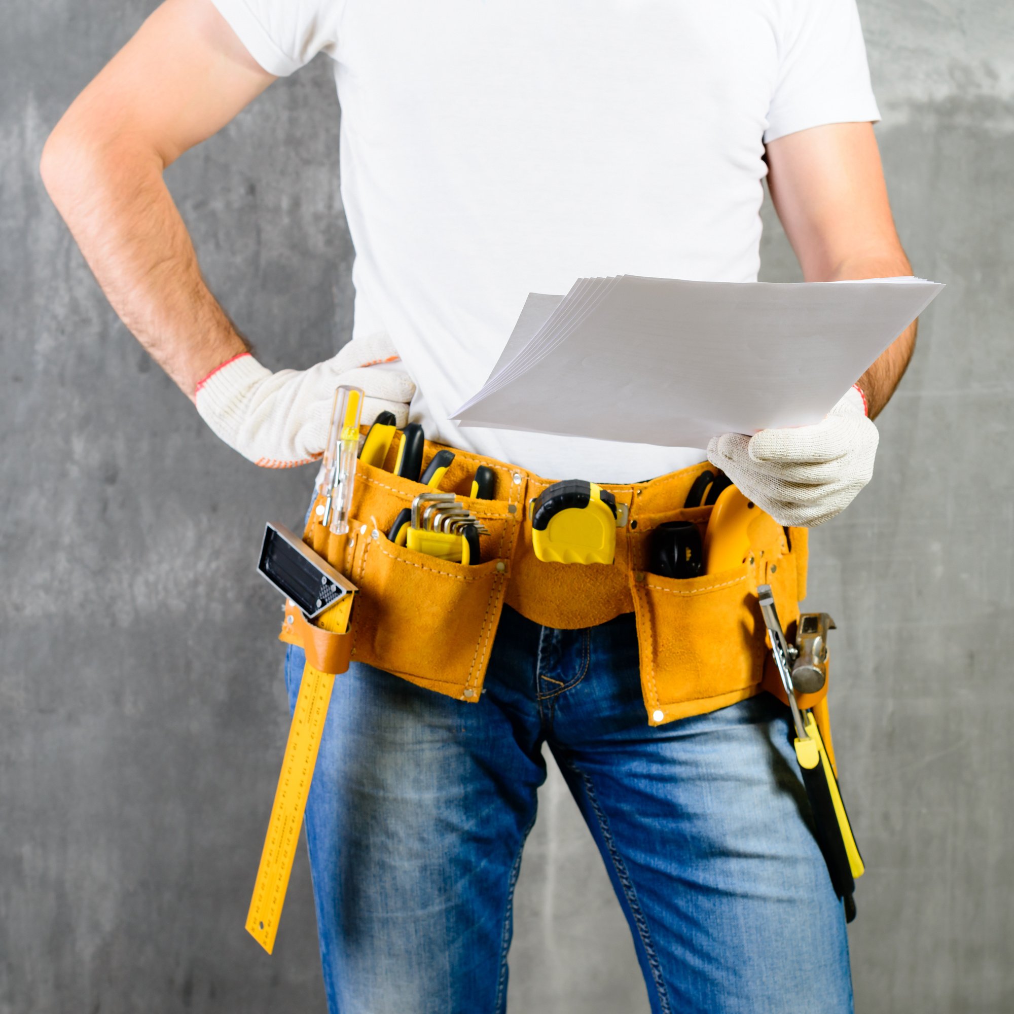 front view of unknown handyman with hand on waist and tool belt